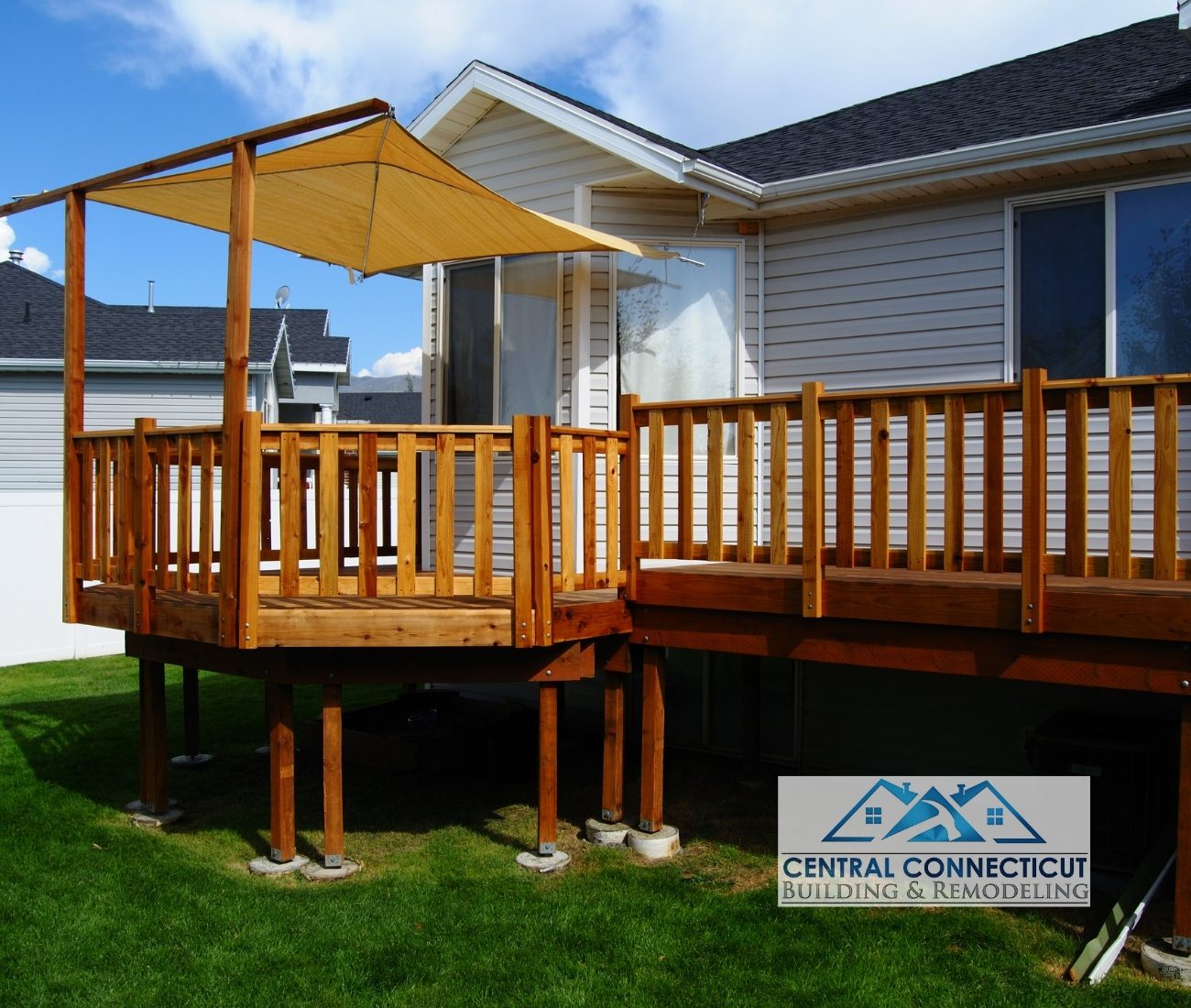 Newly built elevated wooden deck with railing and sunshade canopy, attached to a residential home in Berlin, CT — designed and constructed by Central Connecticut Building & Remodeling.